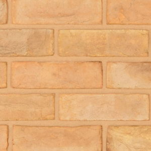 Blenheim Buff handmade brick slips shown in a wall. The bricks are a yellow buff tone with natural creases on the faces. Zoomed in to show detail and texture.