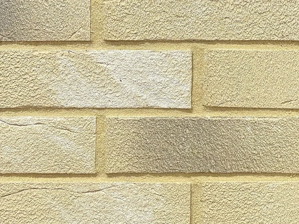 Yellow textured brick slips shown in a wall.