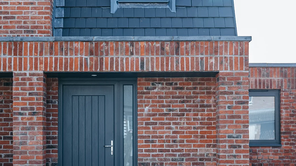 A wide brick faced lintel with a double soldier course above the entrance to a building. The lintel is an example of what could be achieved with a prefabricated lintel unit.