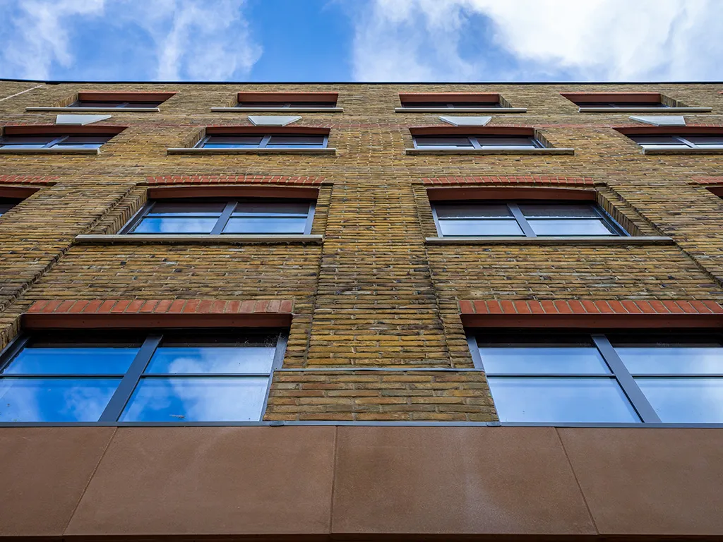 Upward facing view of Drury Lane office renovation in London, showing the brick slip cladded facade and brick faced lintels.