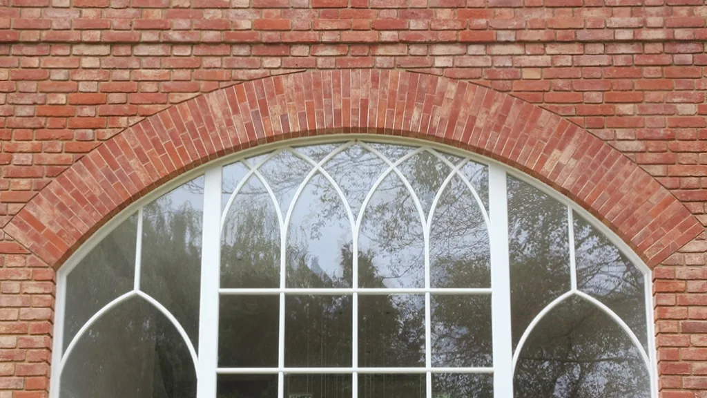 A large curved brickwork arch positioned above a a curved, double height feature window. The arch is an example of what could be achieved with a prefabricated arch unit.